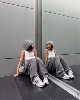 TingTing Lai in grauem Adidas-Look vor einer Metallwand, gespiegelt