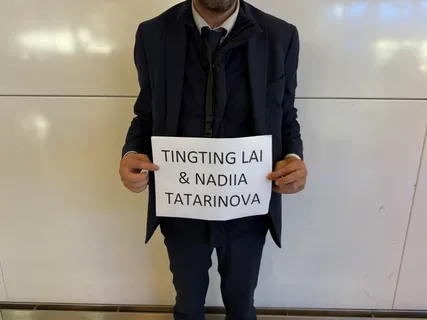 Ein Fahrer mit einem Schild mit der Aufschrift TingTing Lai & Nadiia Tatarinova in der Ankunftshalle in Paris