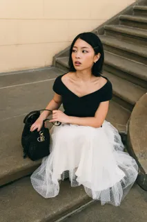TingTing Lai mit Dior-Tasche auf einer Steintreppe