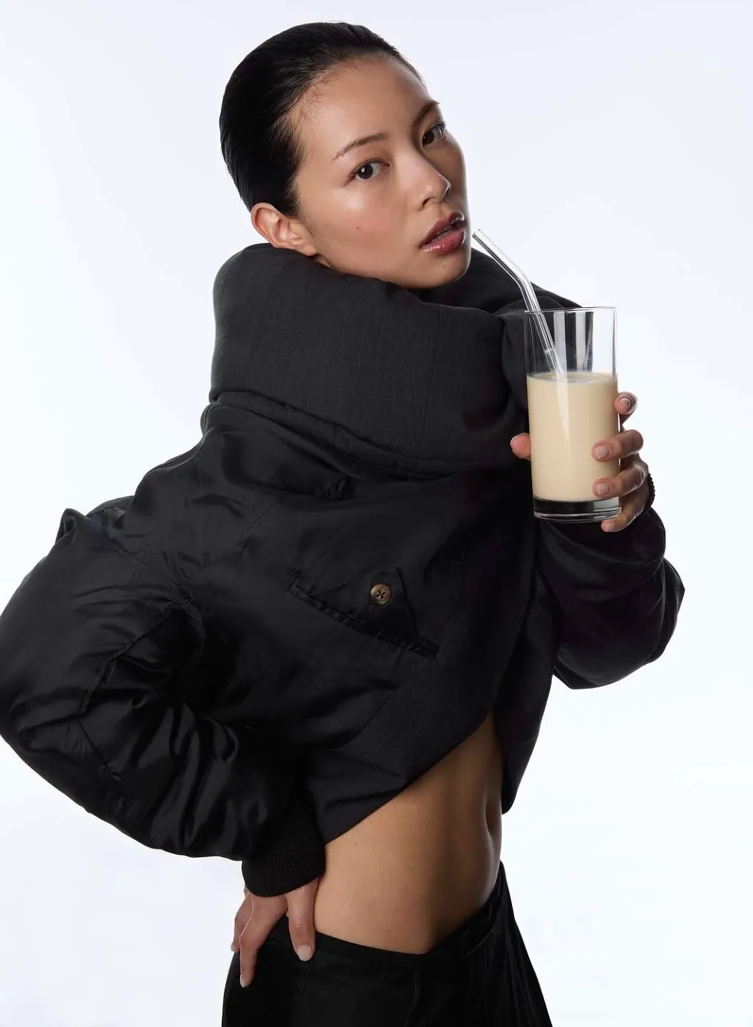 TingTing Lai in einer kurzen schwarzen Pufferjacke mit einem Glas in der Hand (visie.io)