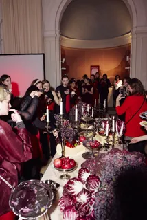 Guests at the red table with candles, radicchio and grapes
