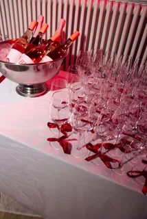 Rosé bottles on ice and glasses tied with red ribbons