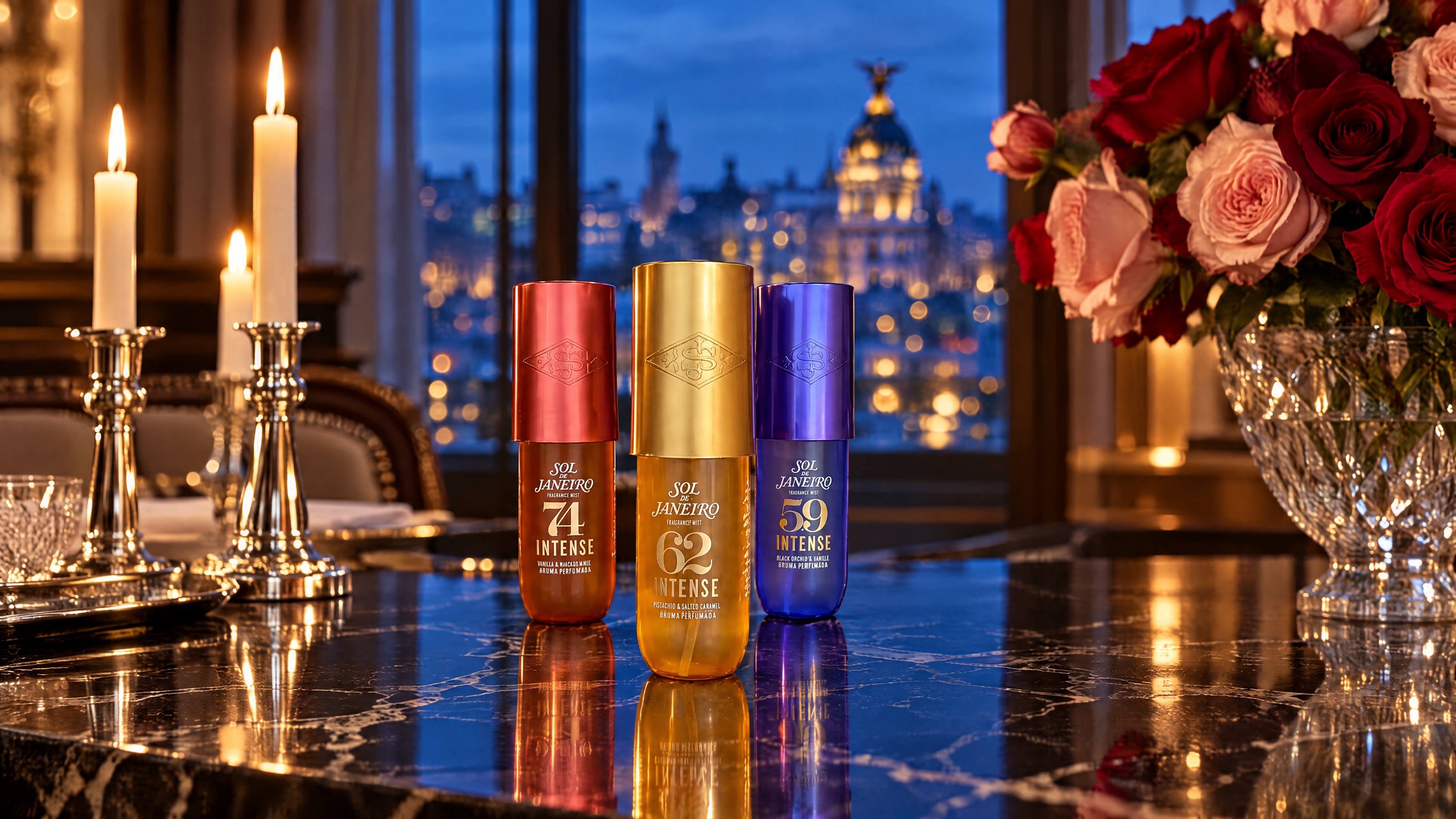Three Sol de Janeiro Intense Perfume Mists on a black marble table between candles and roses, the Madrid skyline at blue hour behind