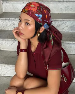 TingTing Lai mit Seidentuch und roter Gucci-Tasche auf einer Marmortreppe