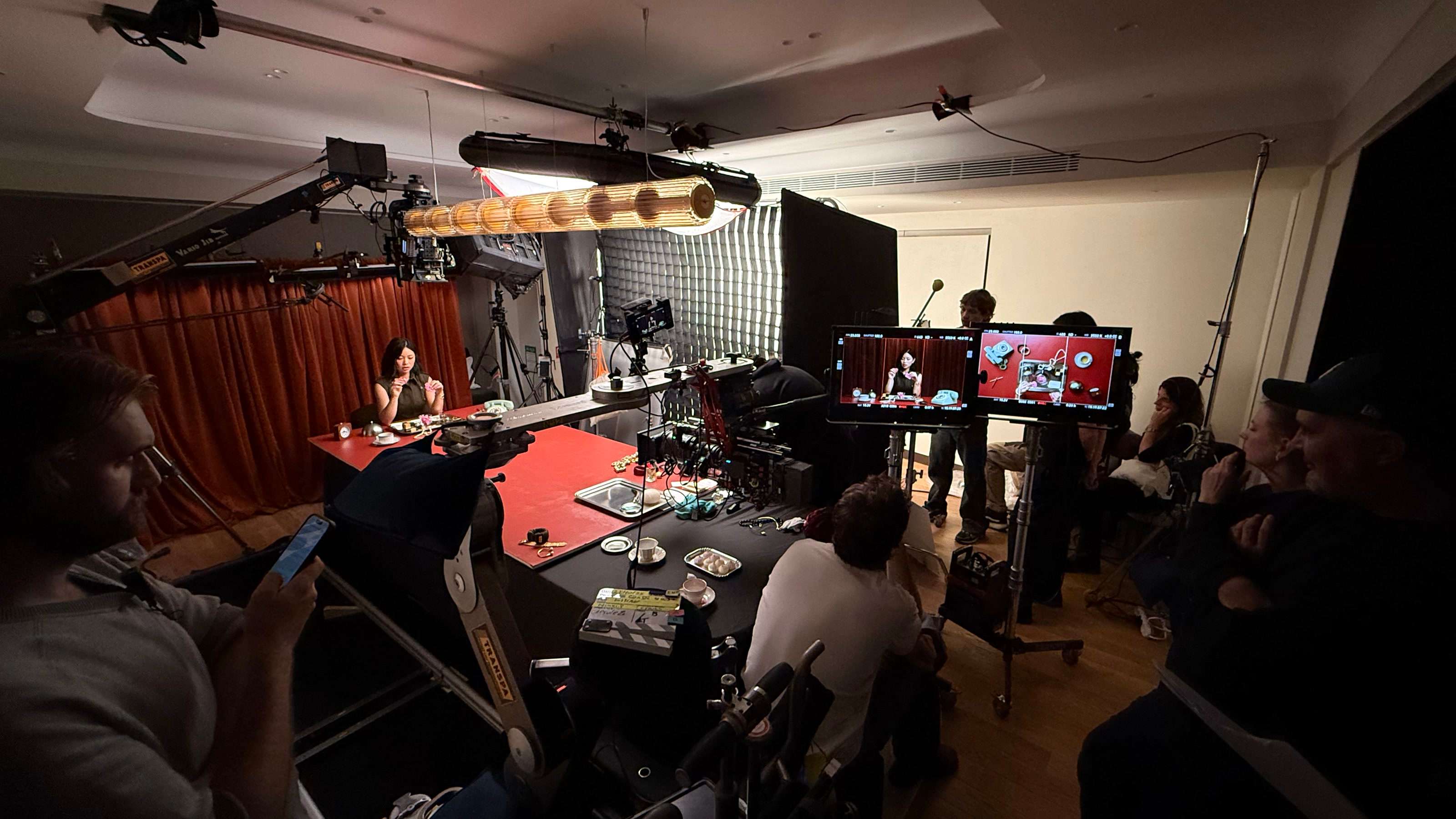 On set for Kilian Paris in Paris: creator TingTing Lai at a red table, the camera crane, monitors and crew around her