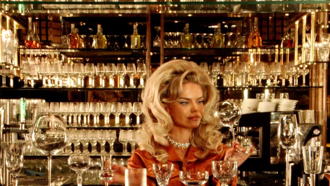 Aliona Gris at a bar lined with crystal glasses, a scene from The Intense Diaries
