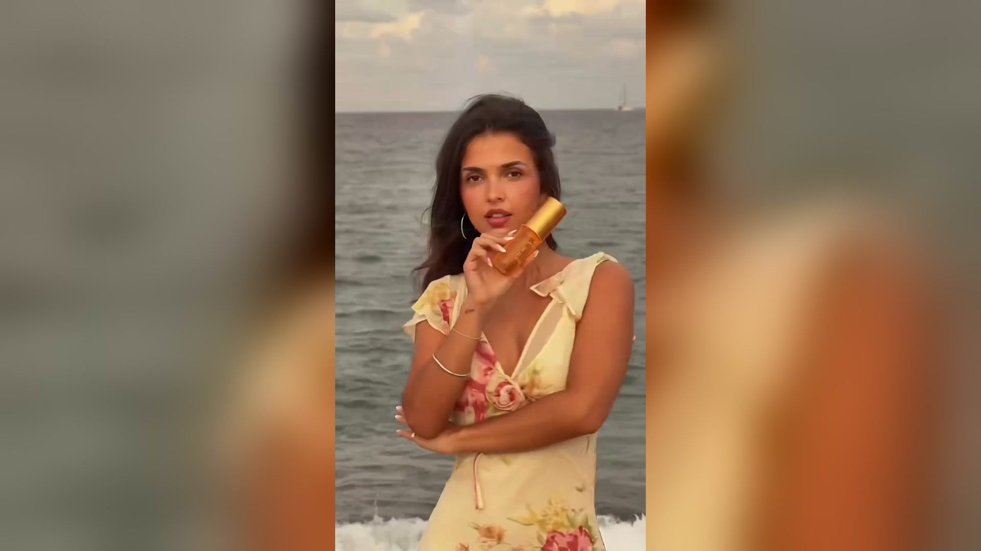 Creatorin am Meer hält einen Intense Perfume Mist von Sol de Janeiro in die Kamera
