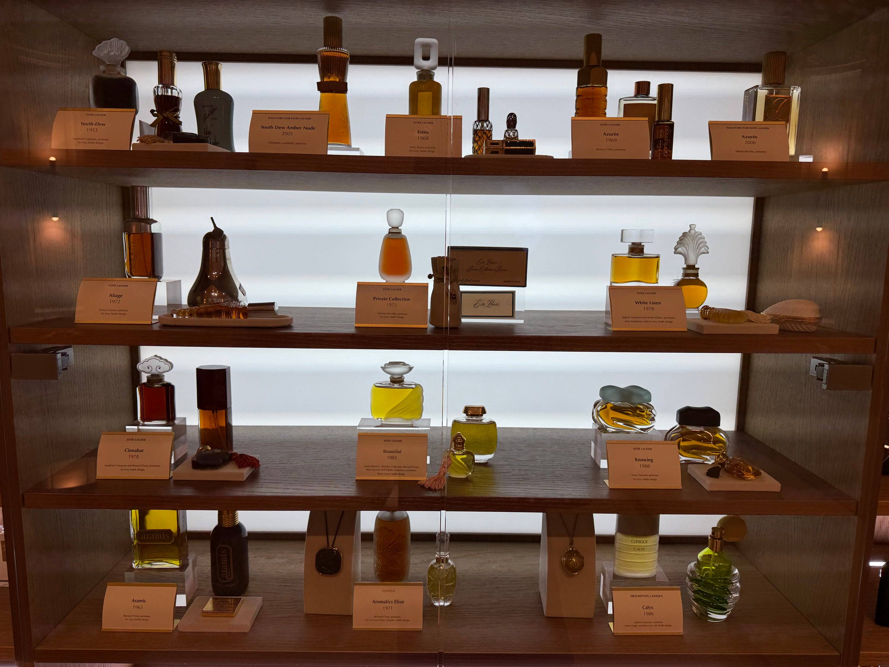 Lit shelves of perfume bottles and archive flacons at Kilian Paris