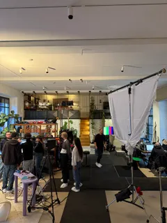 Das Set im Loft mit Licht, einem schwarzen Bodenläufer und der Crew bei der Arbeit