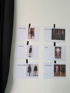 Ausgedruckte Looks an der Studiowand, nach Designer beschriftet