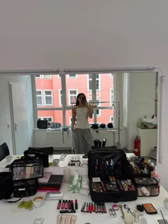 Ein Make-up-Tisch voller Produkte vor einem Spiegel