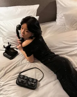 TingTing Lai mit Michael-Kors-Tasche auf einem Hotelbett