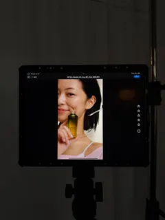 Ein Monitor zeigt TingTing Lai mit einem Produkt von Estée Lauder am Gesicht