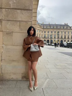 TingTing Lai in brauner Lederjacke mit silberner Prada-Tasche, Paris