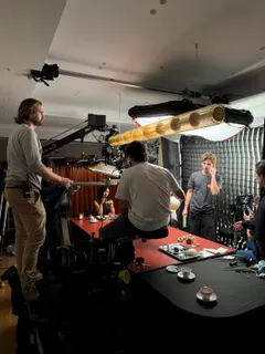 Filmteam, Kran und Licht rund um den roten Tisch am Set von Kilian