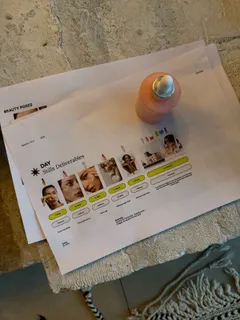 Eine ausgedruckte Shotliste mit Produktfotos auf einem Steintisch, daneben ein Flakon