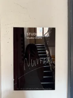 Ein schwarzes Schild mit der Aufschrift Studio 1, Studio Chérie, darauf handschriftlich Numéro