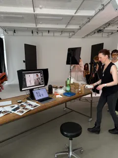 Die Crew am Capture-Platz im Studio, Monitor und ausgedruckte Proofs auf dem Tisch