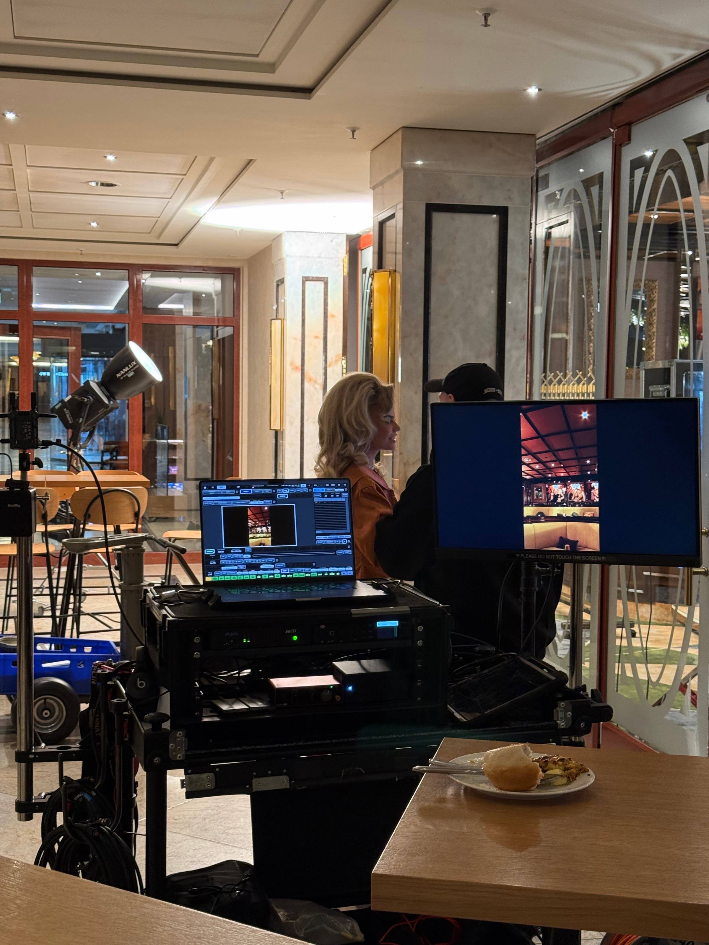 Monitors and the playback desk at the Sol de Janeiro shoot in a Berlin hotel bar, Aliona Gris in the background